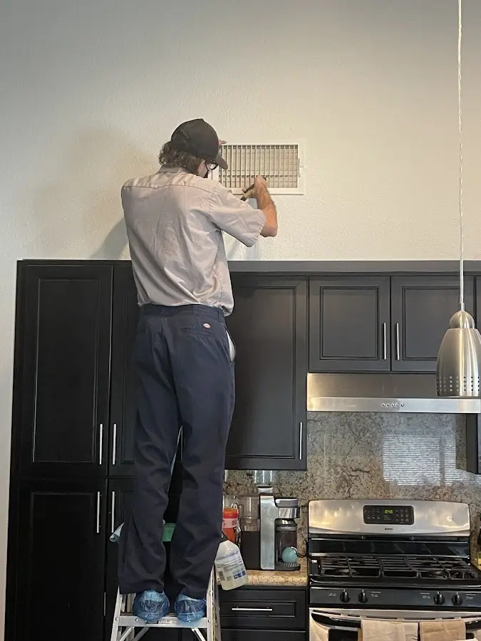 Technician inspecting an air vent during HVAC service in Black Diamond